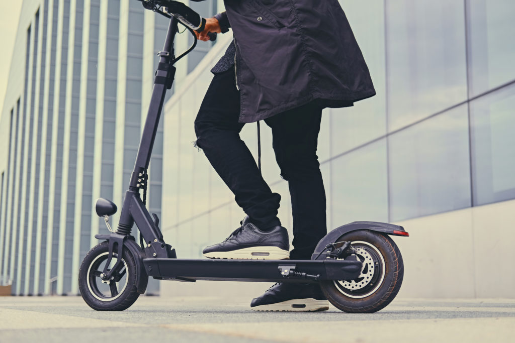 Close up image of a man on an electric scooter.